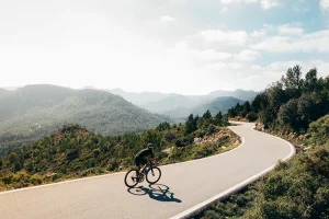 bicyclist on winding road in the mountains
